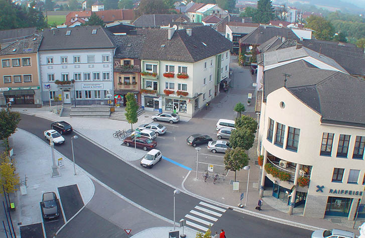Das Gebäude der UNIQA Generalagentur Hauser und Partner aus der Vogelperspektive mit dem umliegenden Marktplatz.